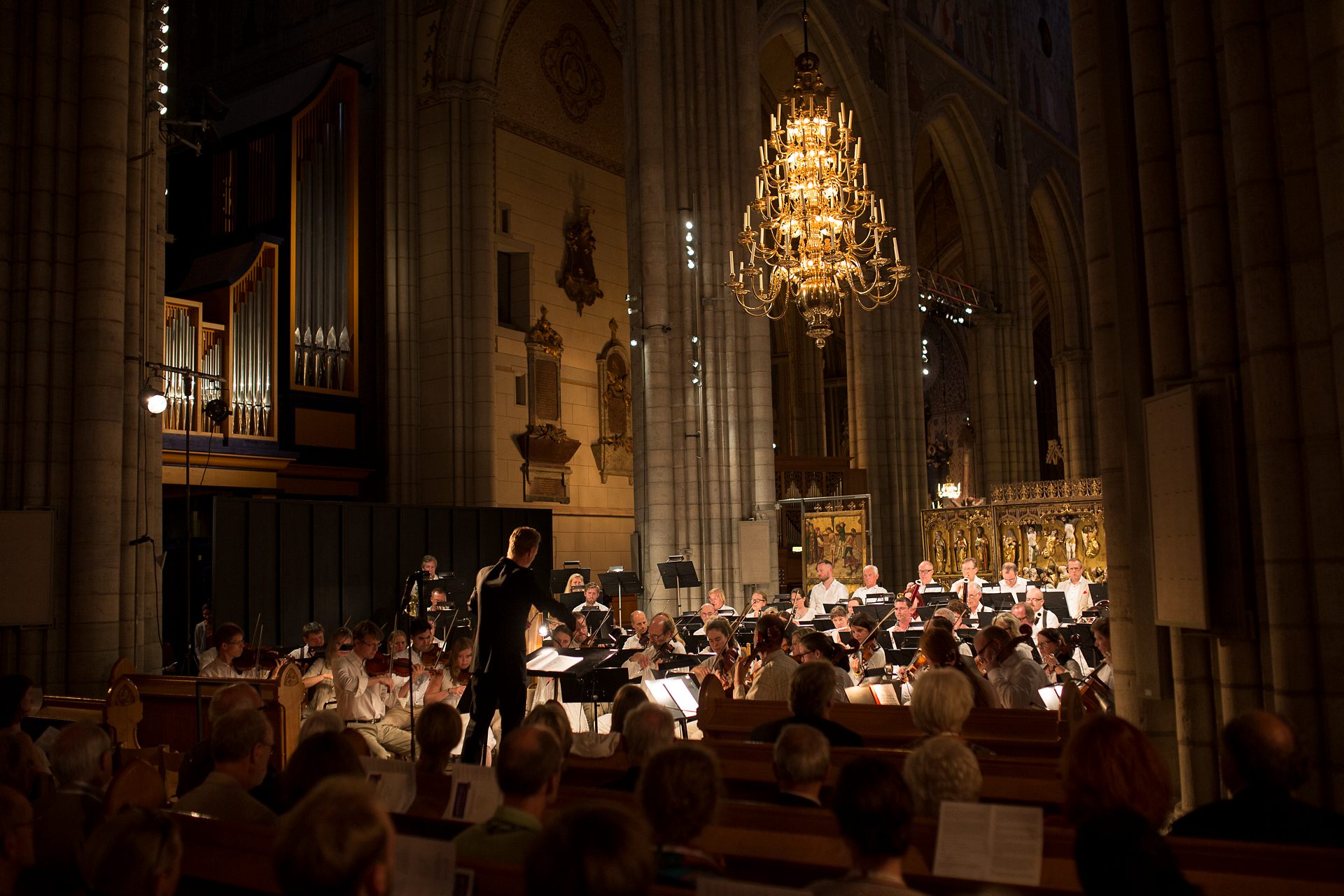 Orkester med dirigent spelar i kyrka.