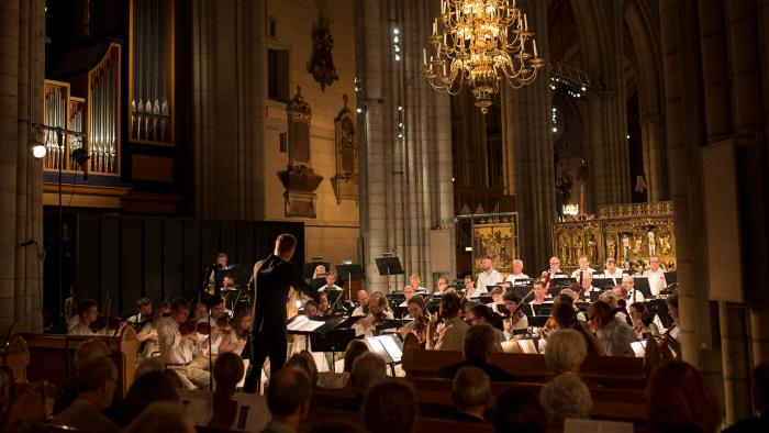 Orkester med dirigent spelar i kyrka.