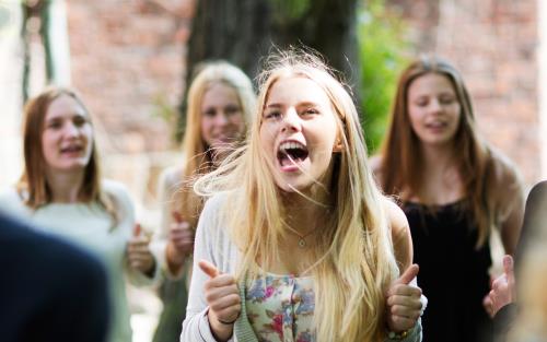 Glada ungdomar utanför kyrka, sommarbild