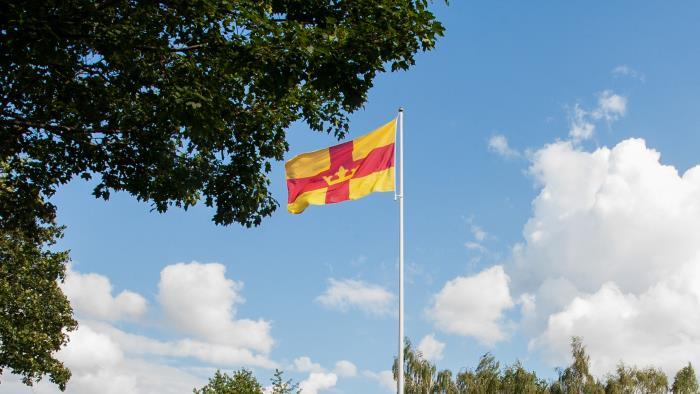 Svenska kyrkans röda och gula flagga vajar i vinden.