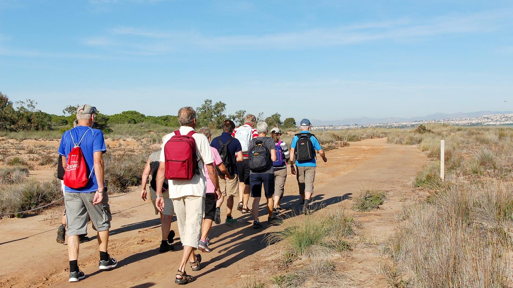 Pilgrimsvandrare på savannen på väg bort från kameran