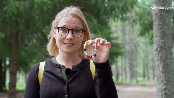 Therese Hamrén håller fram armbandet frälsarkransen.