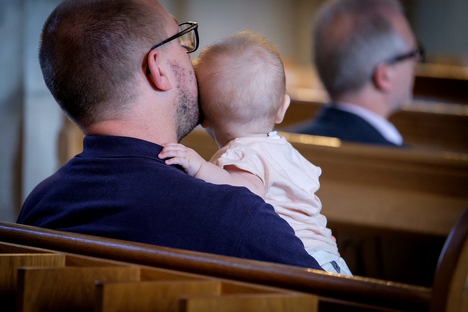 Pappa och barn sitter i kyrkbänken