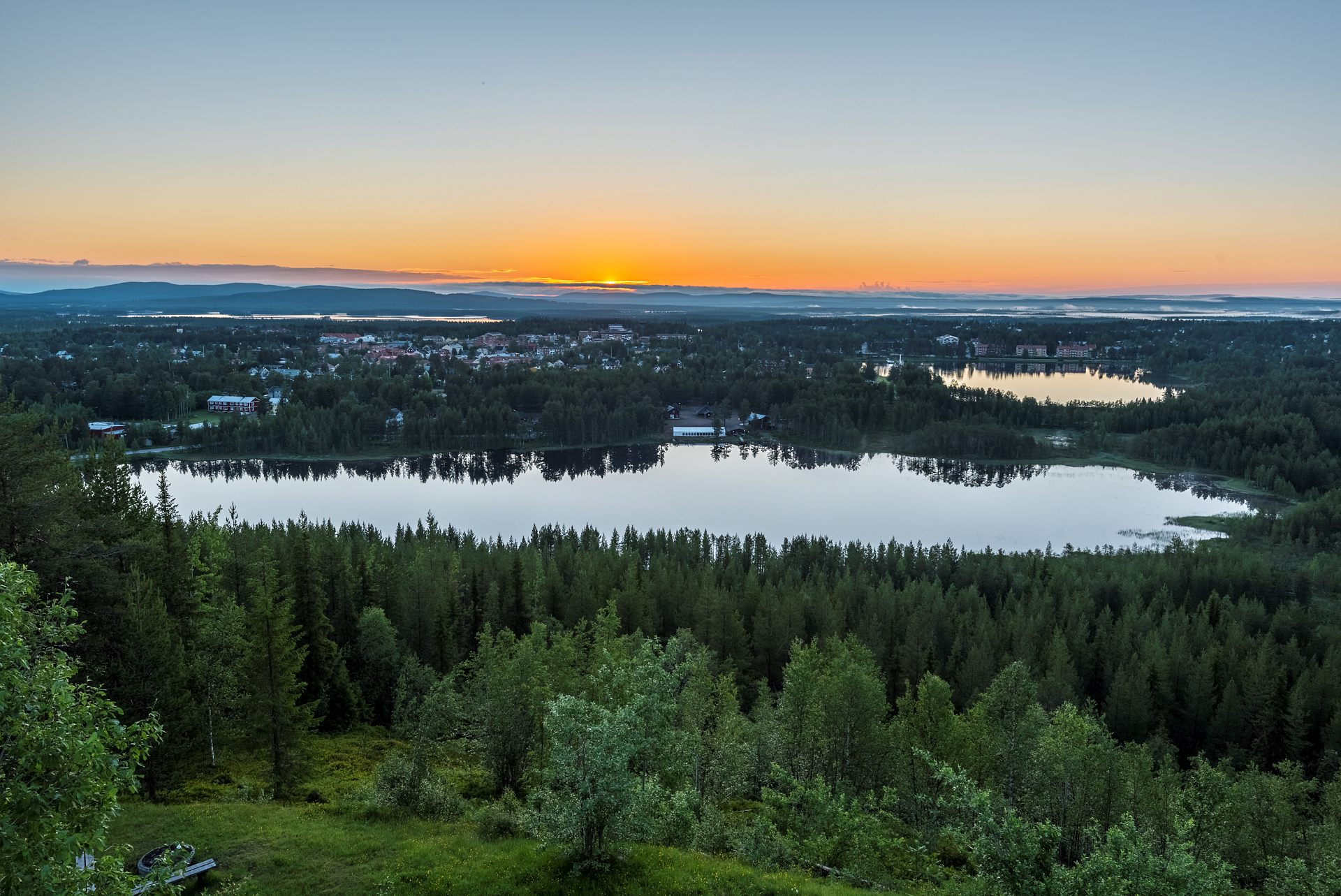 Soluppgång över nordiskt landskap.