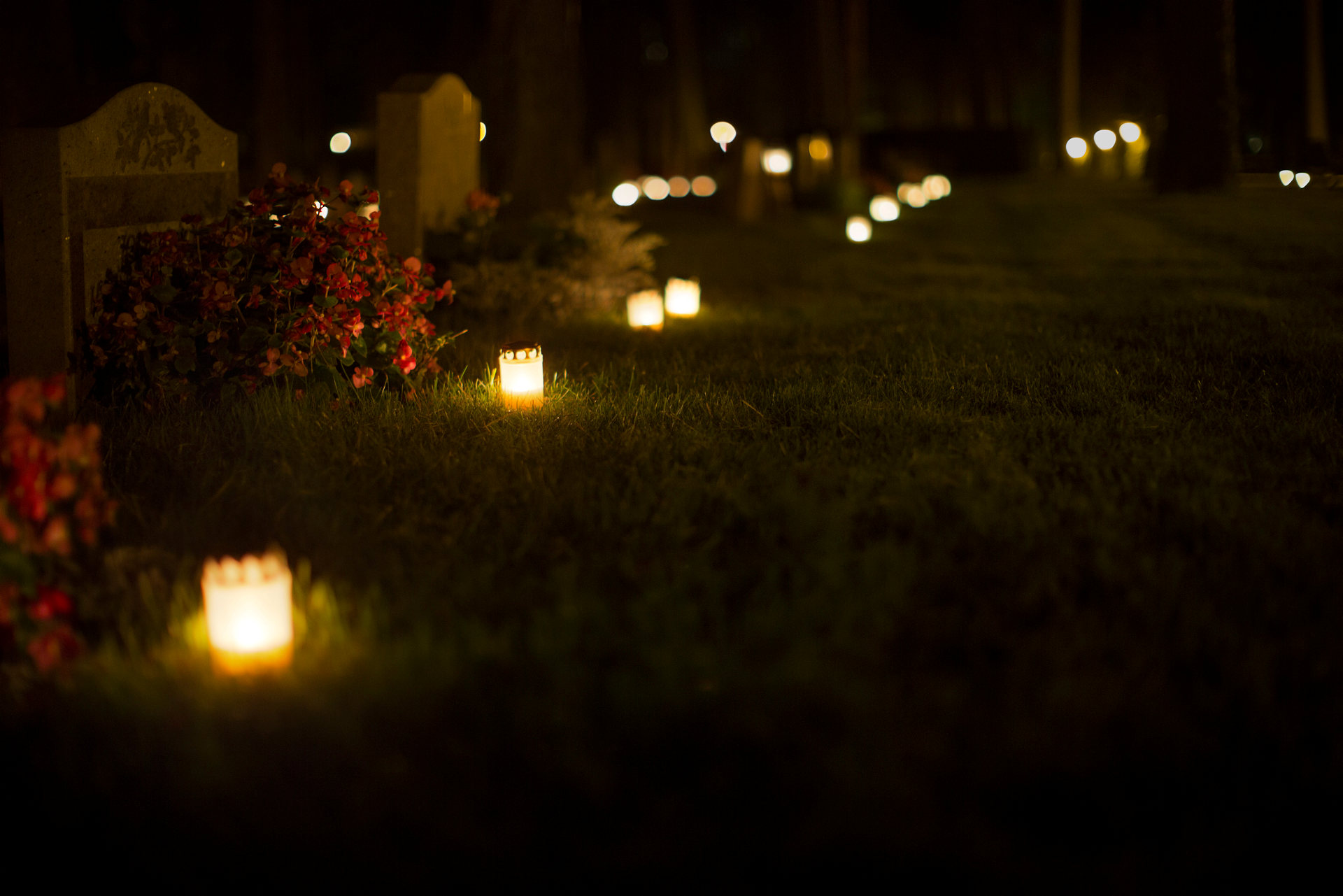 Tända ljus på kyrkogård i mörker