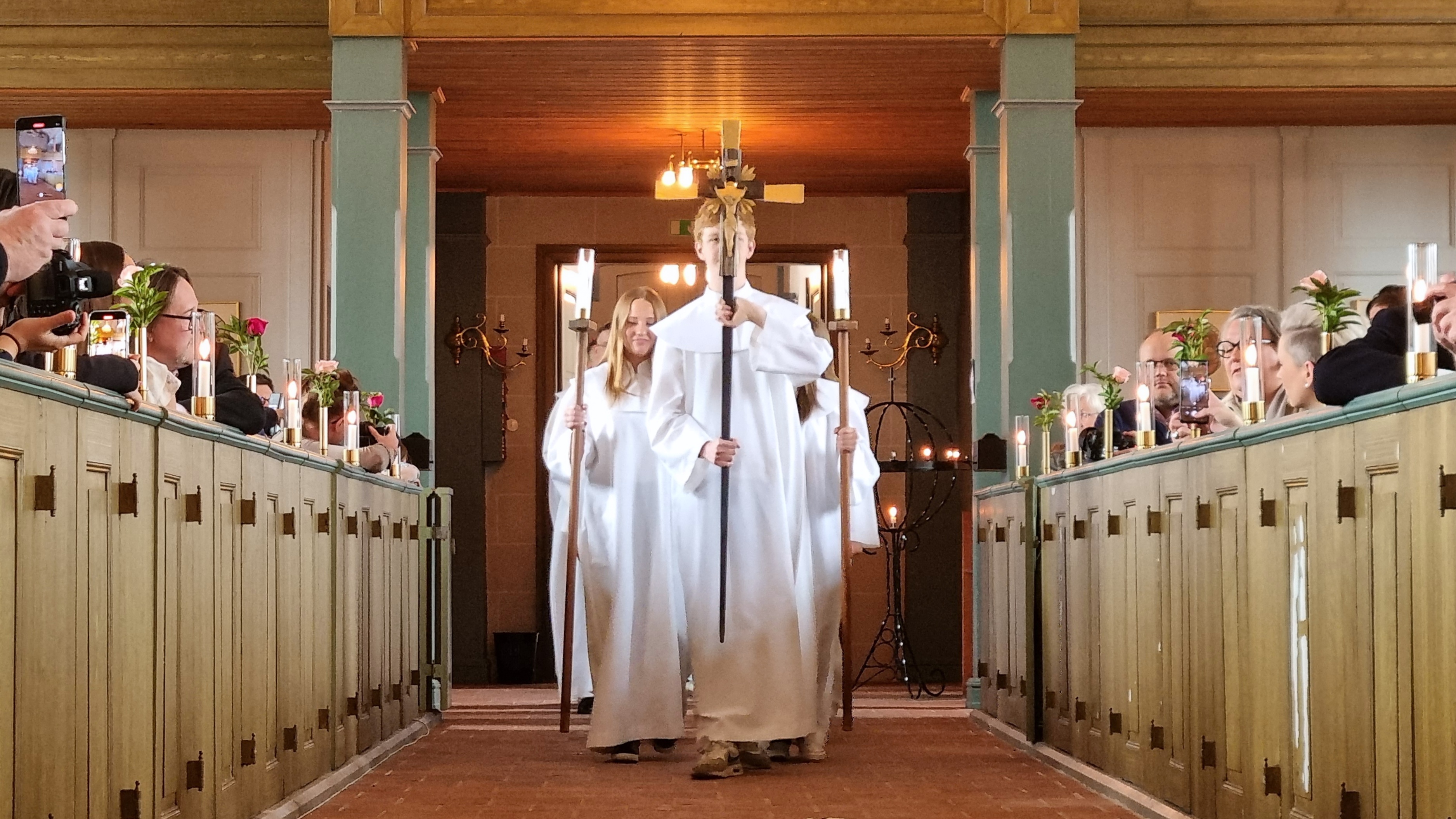 En grupp konfirmander i procession genom kyrkan. 
