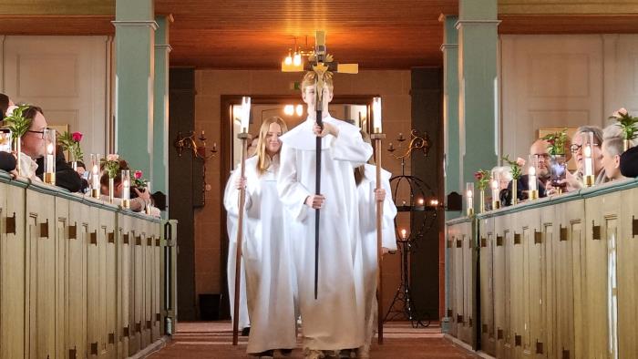 En grupp konfirmander i procession genom kyrkan. 