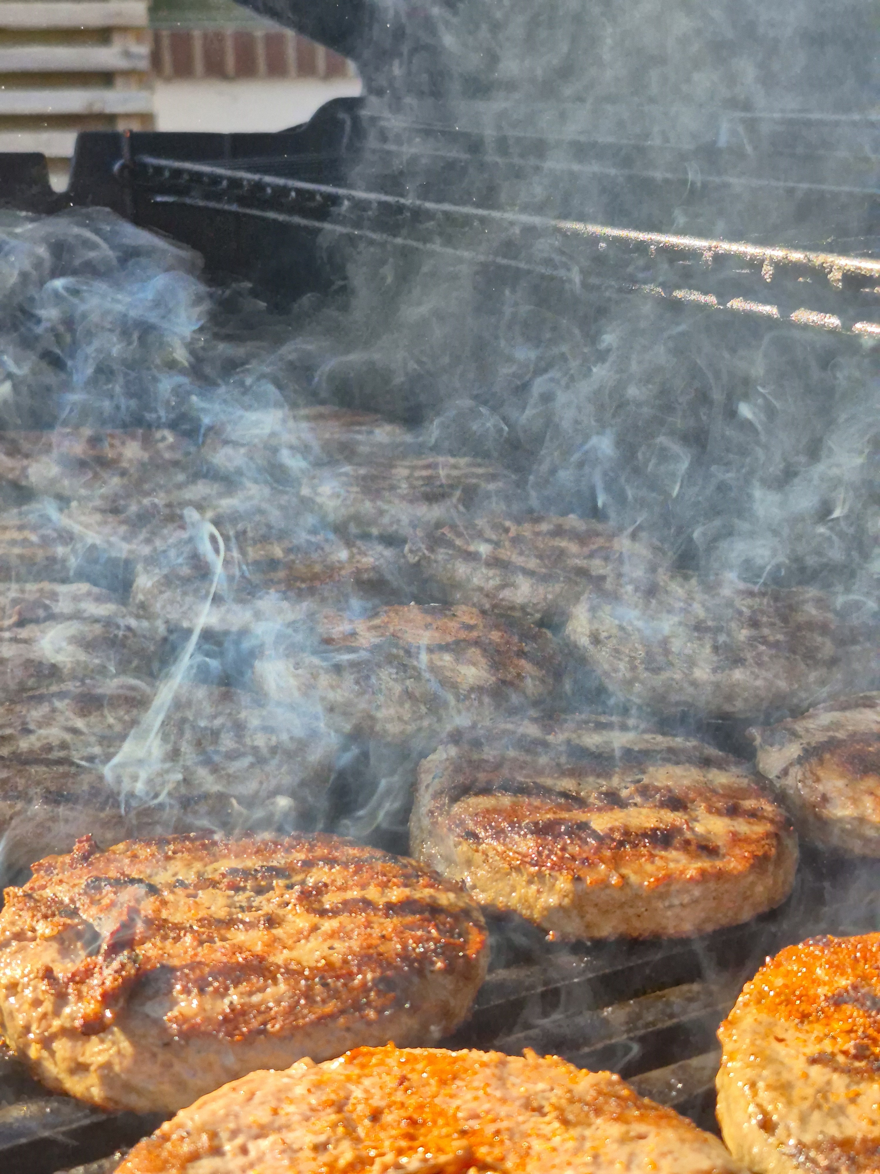 Hamburgare blir grillade på en grill.