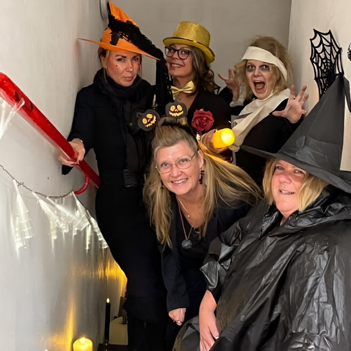 Ett gäng halloween-kläda kvinnor står i en trappa.