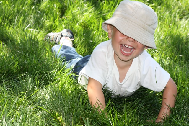 Pojke leker i gräset.