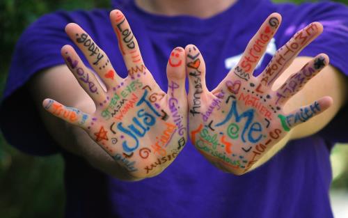 Två händer tecknade med färgpenna ord som beskriver personliga egenskaper.