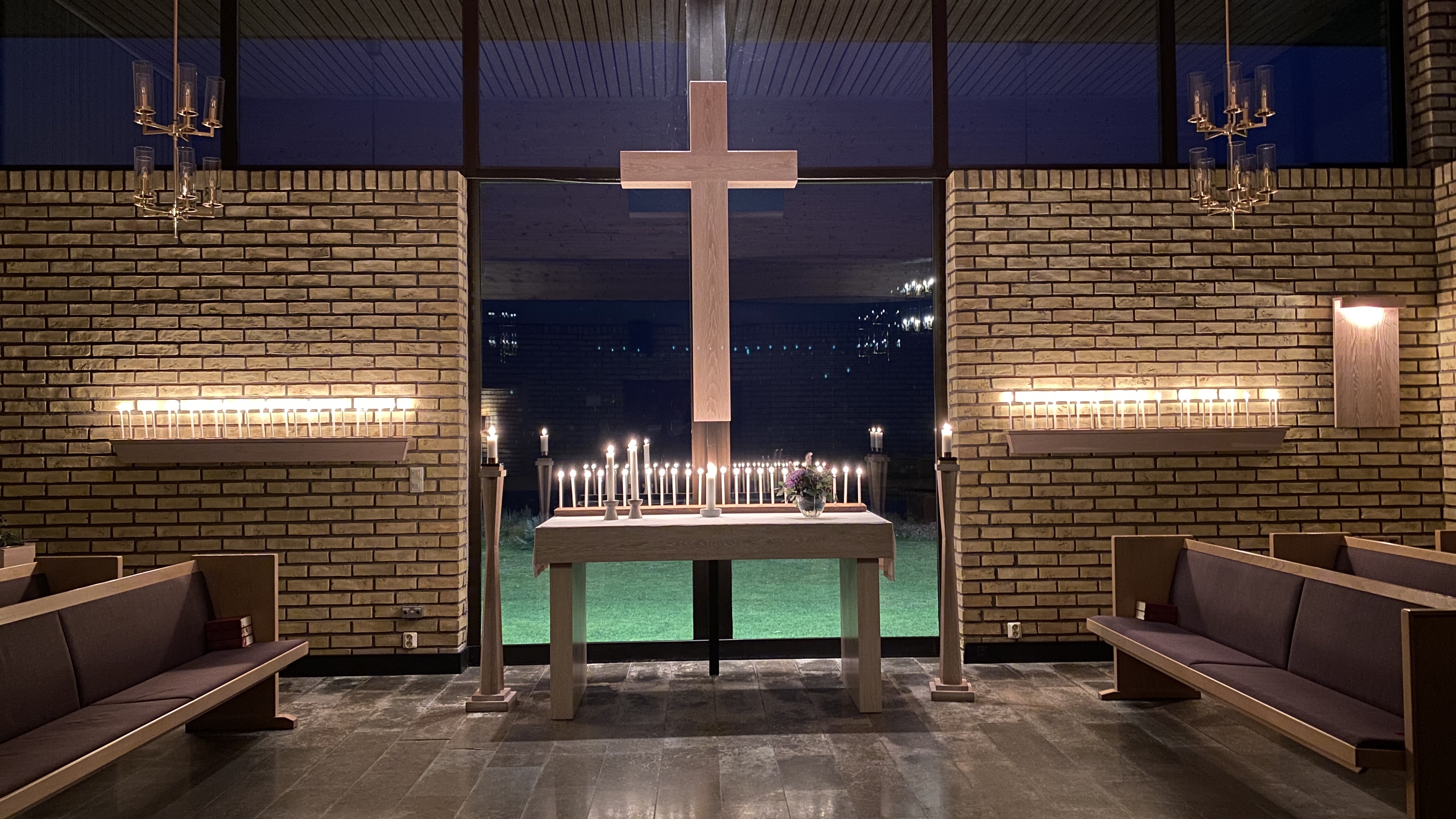 Kapell med altare i form av ett fönster och ljus tända