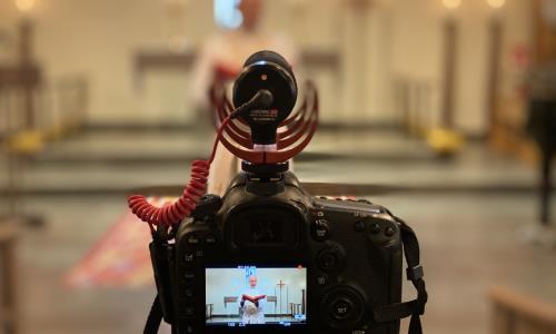 En präst i en kyrka syns genom en kamera