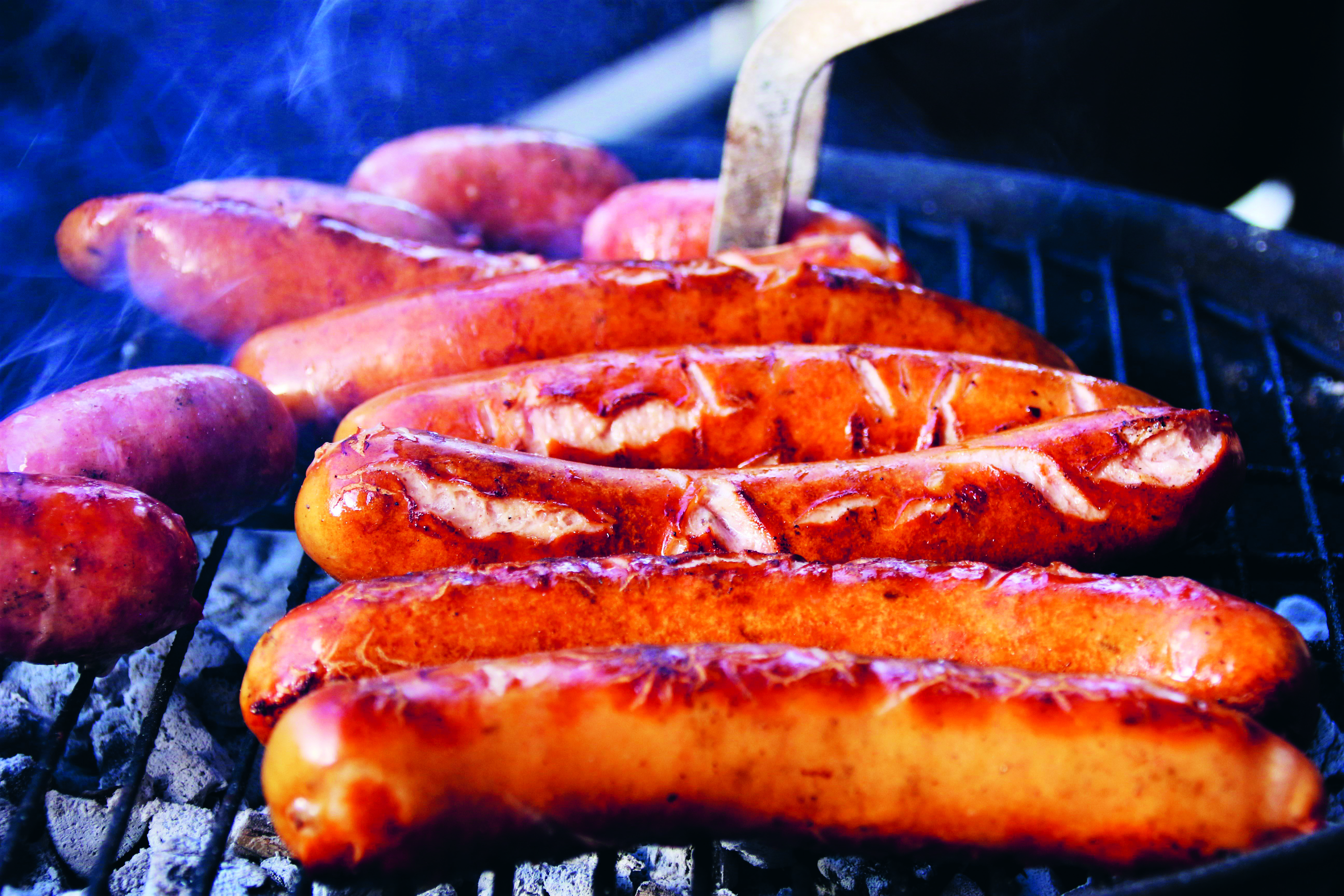Grillade korvar som ligger på en grill.