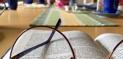 Glasögon liggande på uppslagen Bibel