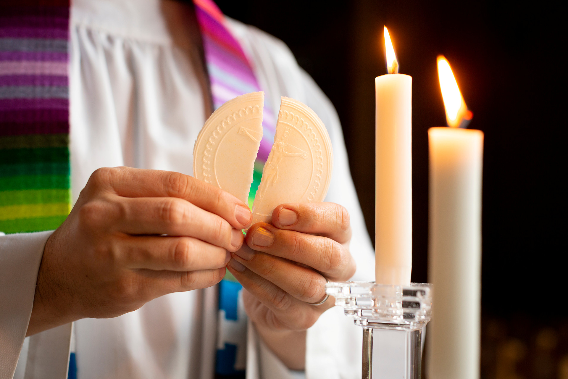 Prästen bryter brödet.