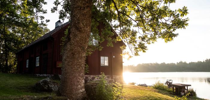 Rödmålat hus vid en sjö.