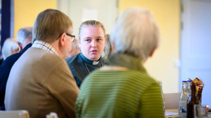 Präst samtalar med människor