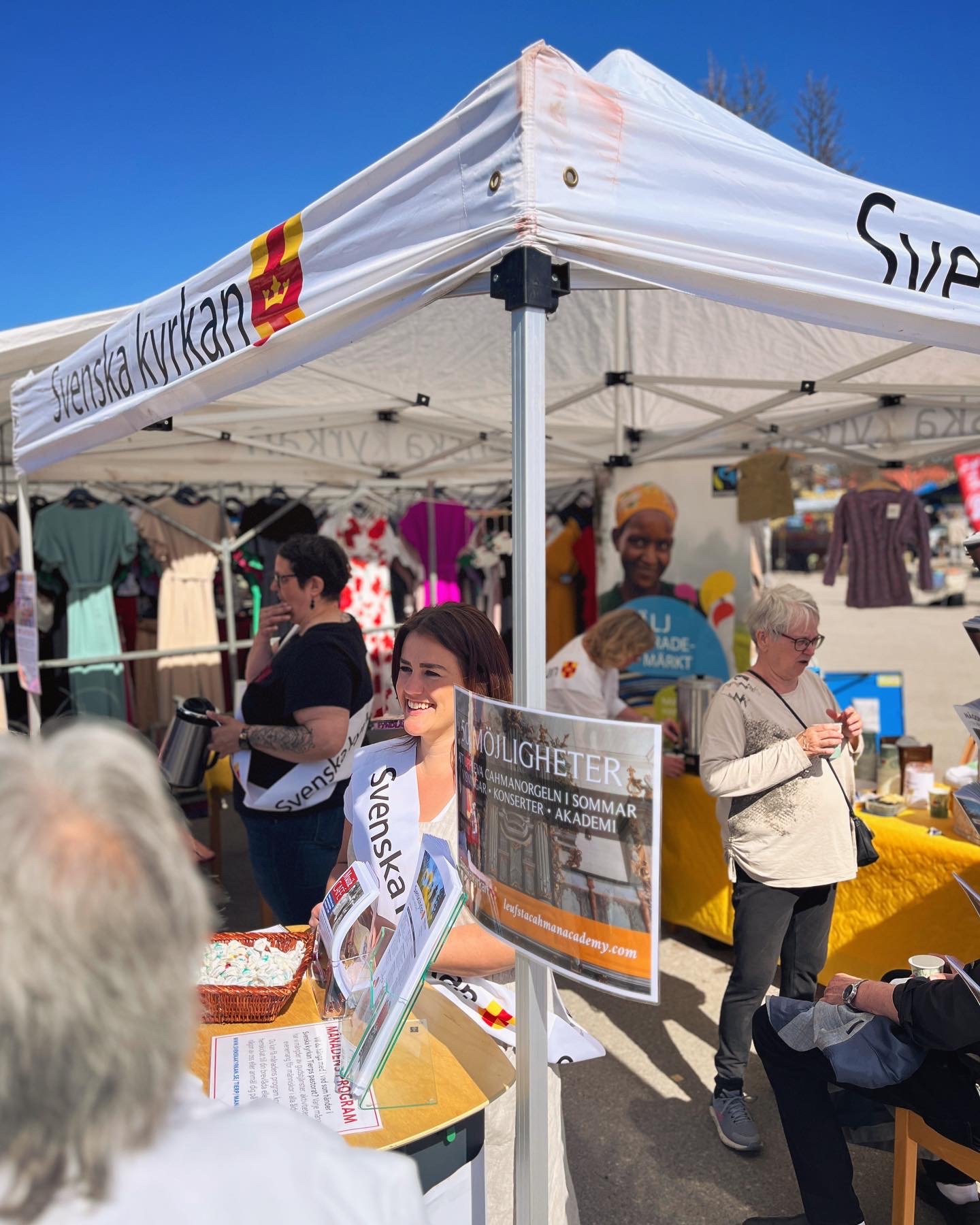 En anställd i Tierps pastorat pratar med människor på vårmarknad.