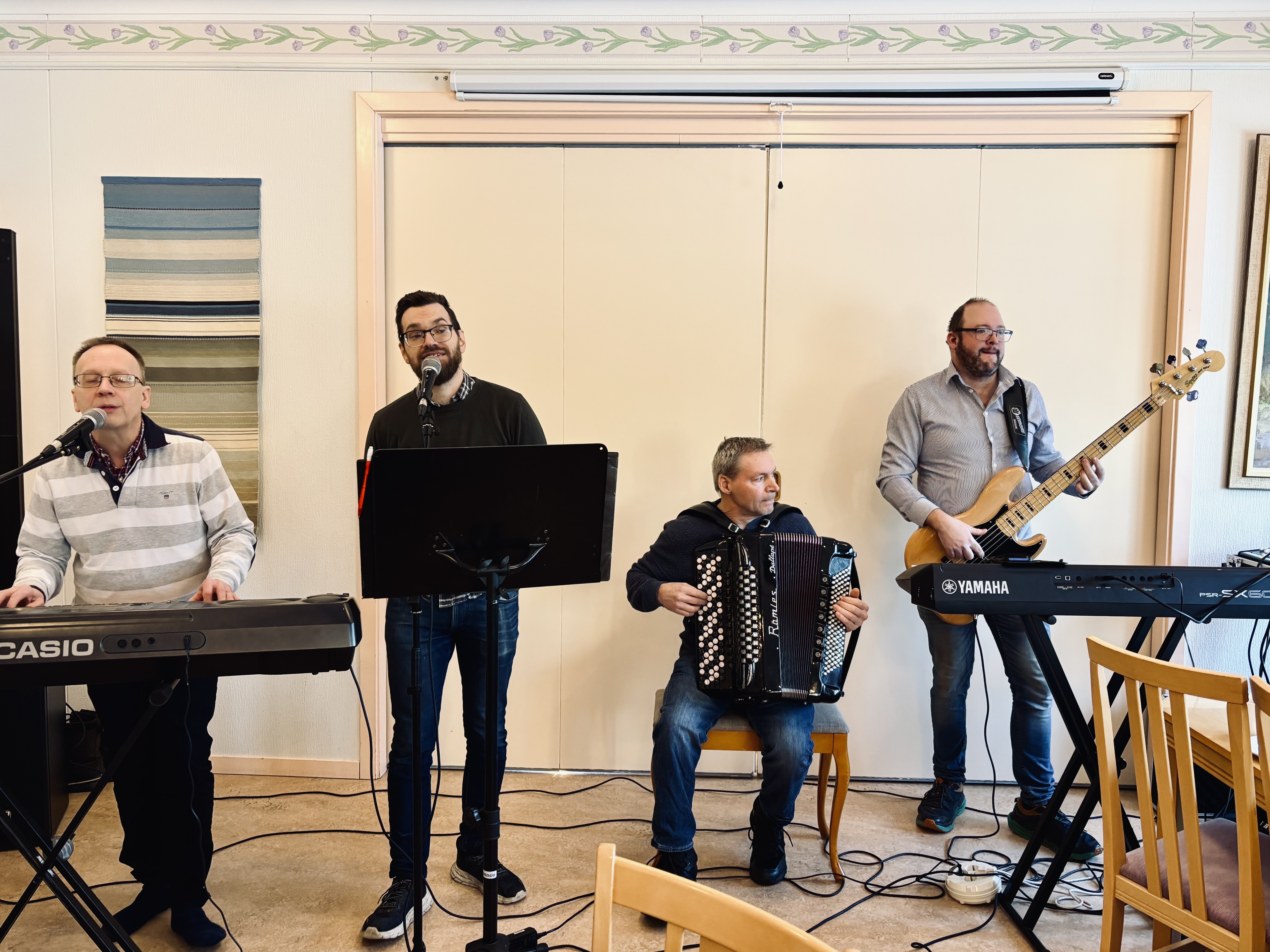 Ett band med fyra män står och spelar instrument.