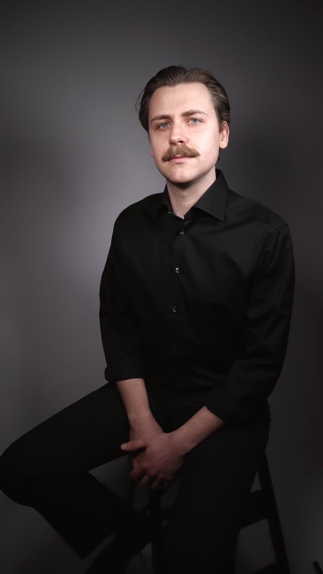 Porträttbild på en ung man med mustasch.