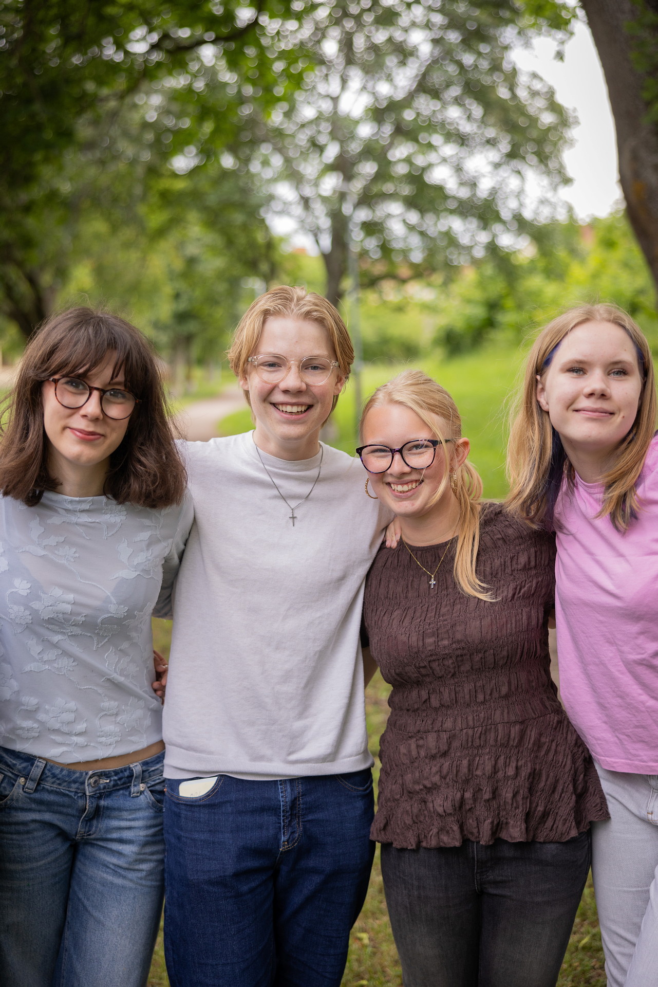 Fyra ungdomar står med natur bakom sig.