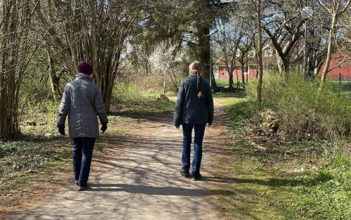 Två personer promenerar under samtal.