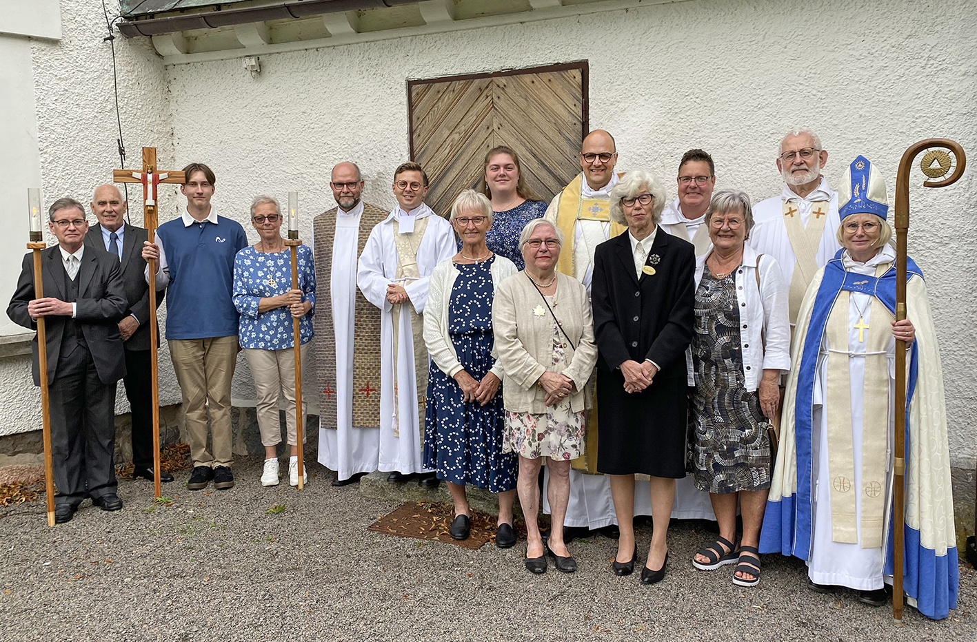 Gruppfoto på biskop Susanne Rappmann, den nye kyrkoherden Johannes Bäckman tillsammans med medverkande präster, personal och församlingsaktiva.