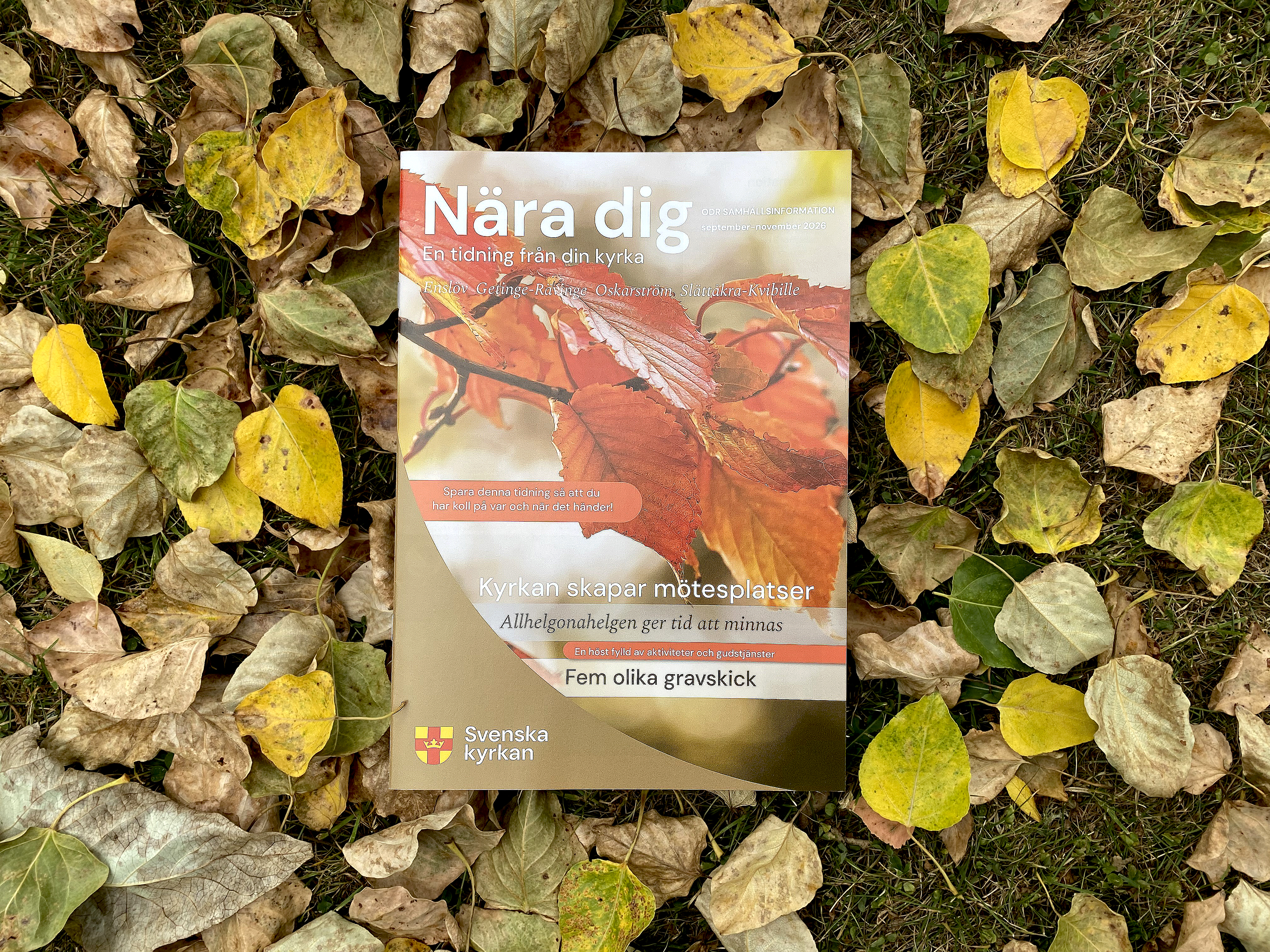 Församlingstidningen Nära dig ligger på en bädd av höstlöv.