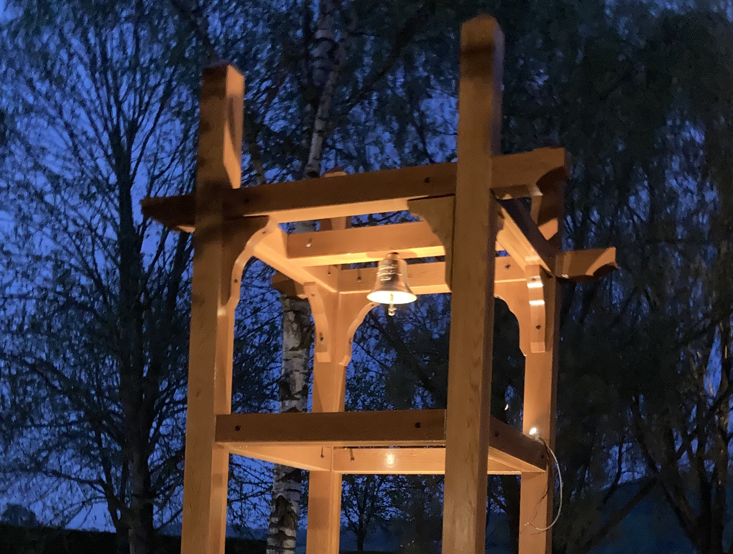 Övre delen av nya klockstapeln i kvällsbelysning.