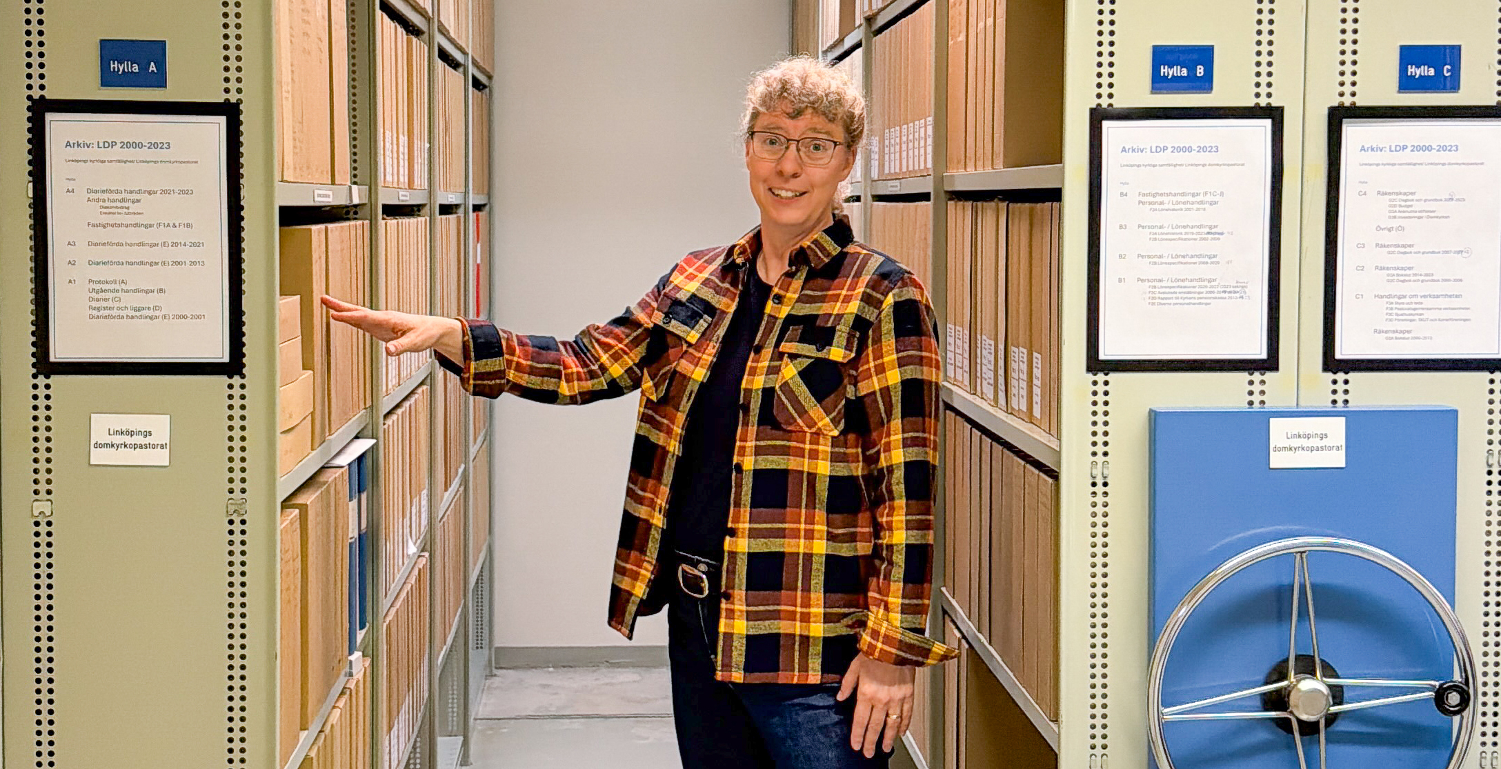 Elisabeth Olofsson bland hyllor och pärmar i Svenska kyrkan i Linköpings arkiv
