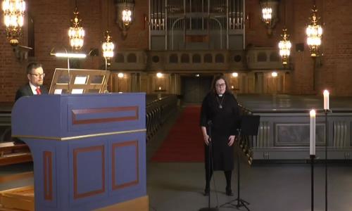 En kvinna sjunger i en kyrka och ackompanjeras av en man som spelar orgel.