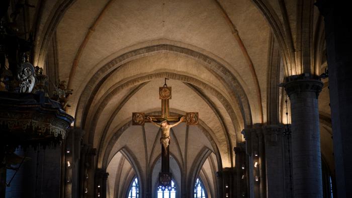 Kyrkorum med upplysta valv, i centrum av bilden ett triumfkrucifix.