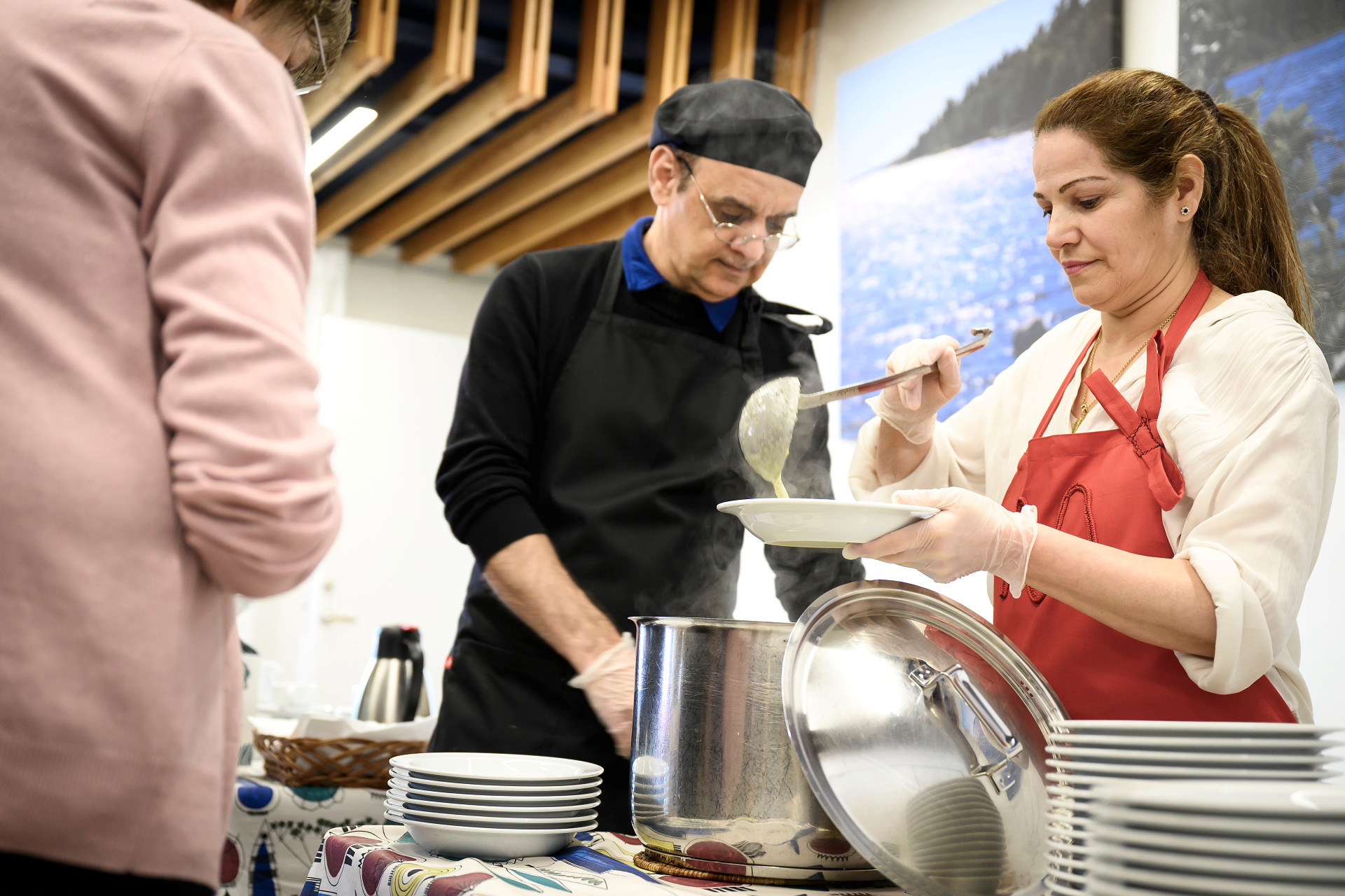 Kökspersonal lägger upp mat till be gäst.