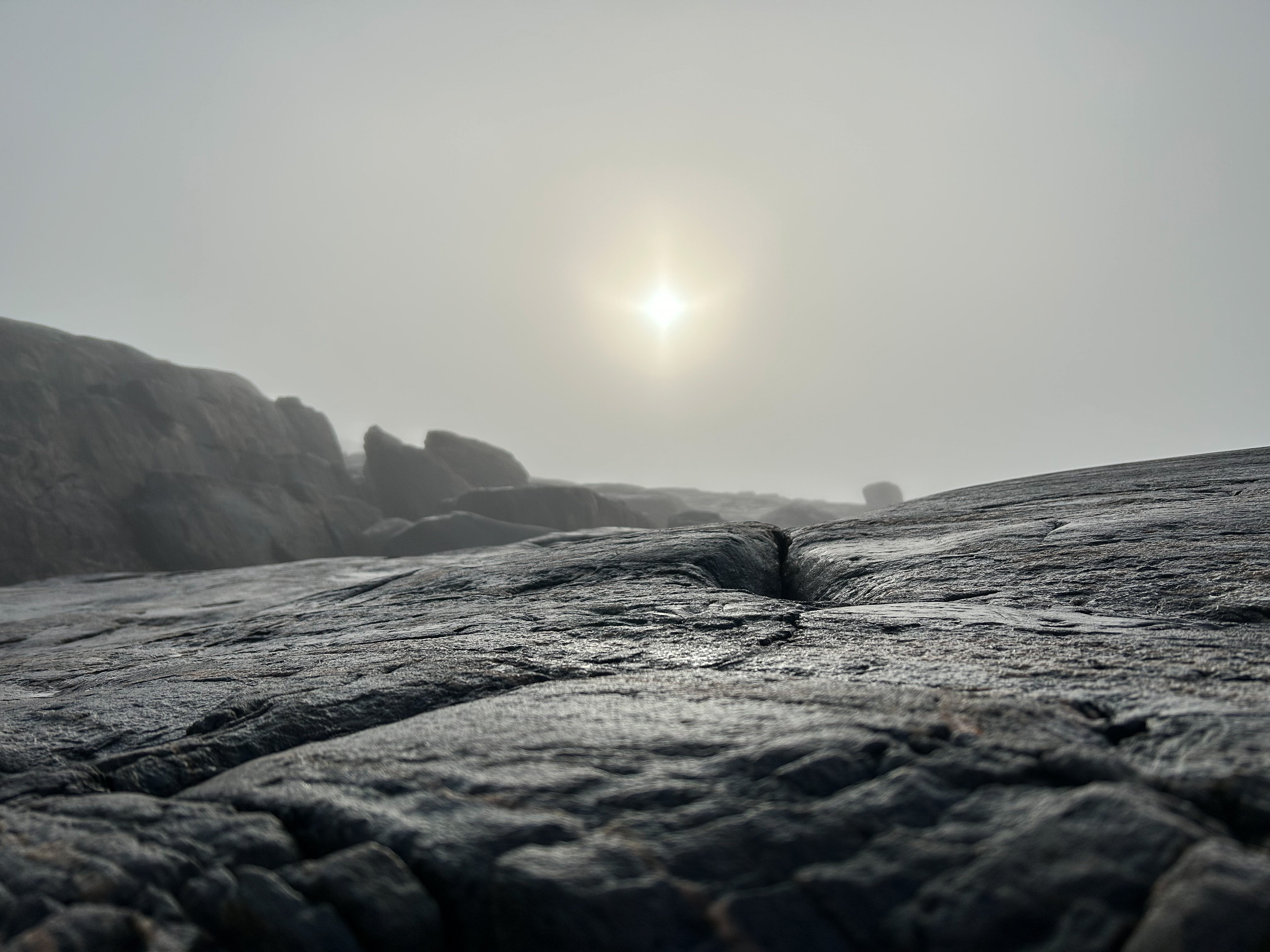 Aurinko paistaa sumunpilven takaa.