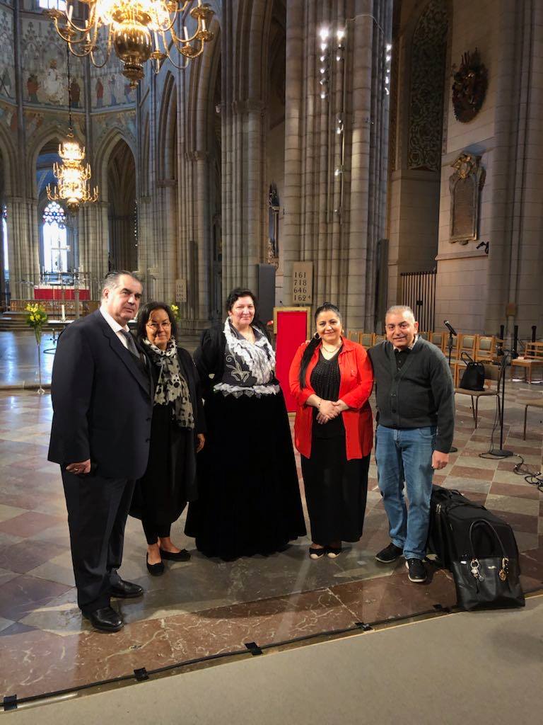 Tre romska kvinnor och två män står i Uppsala domkyrka.
