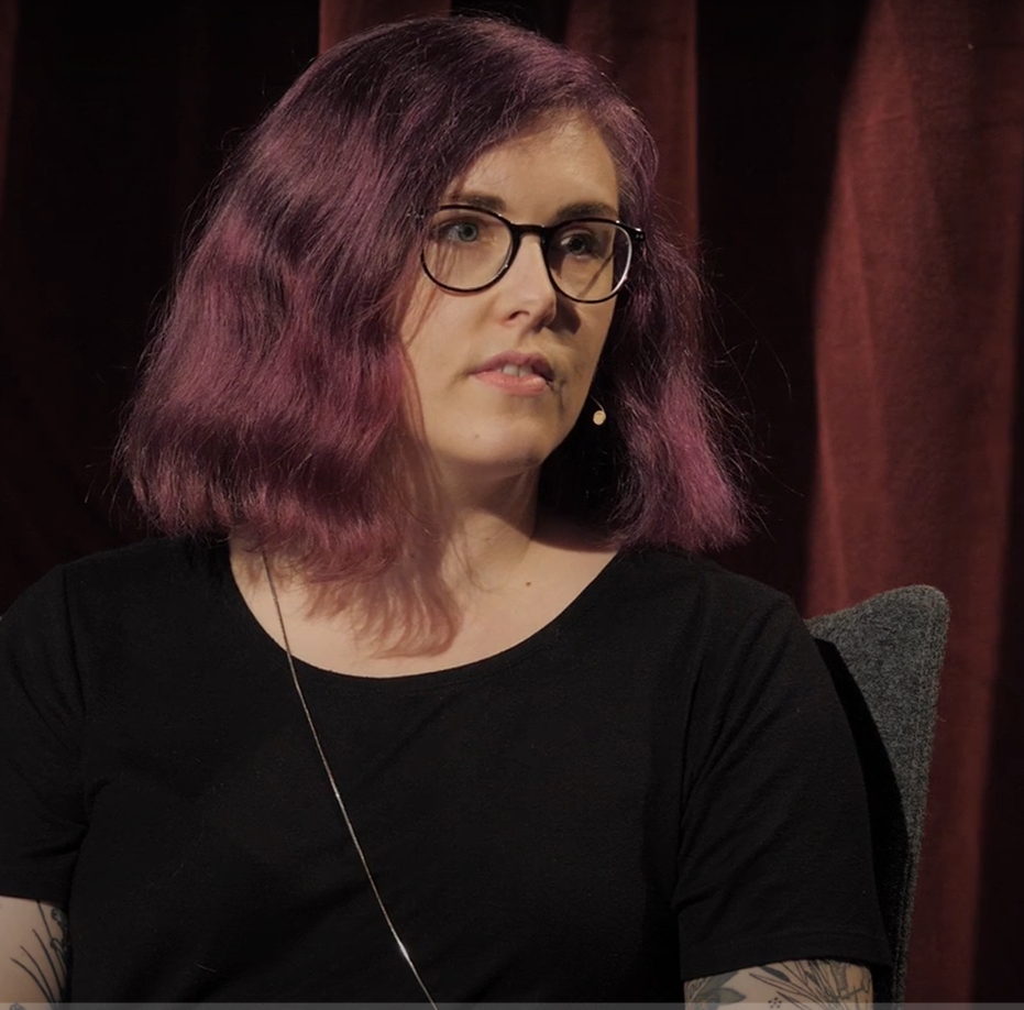 Kvinna med mörkt hår tittar åt höger