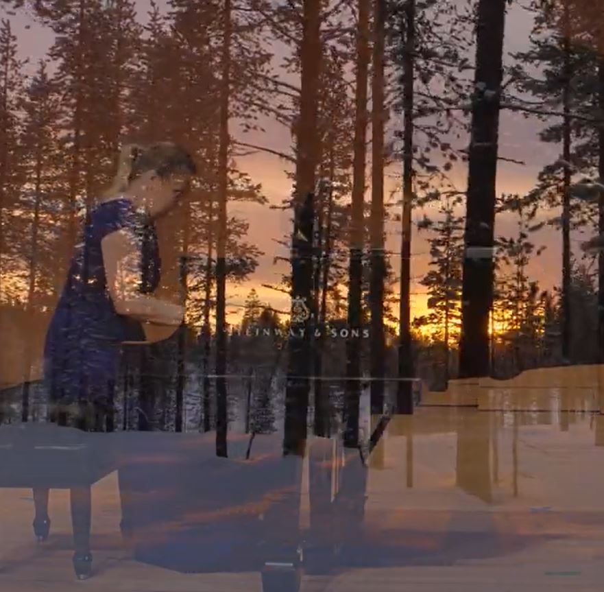 Pianisti flyygelin äärellä taustalla auringonlasku.