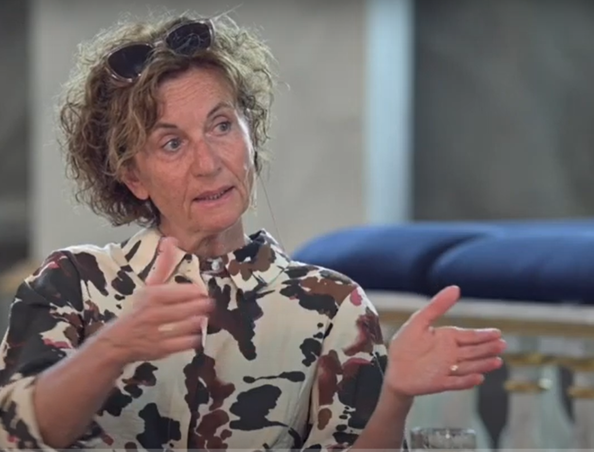 Kvinna sitter i kyrkan och berättar.