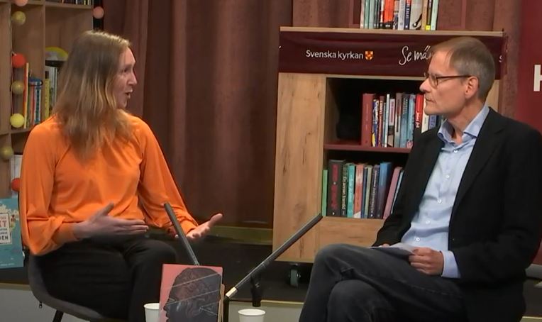 Kvinna och en man samtalar i bokhandel.