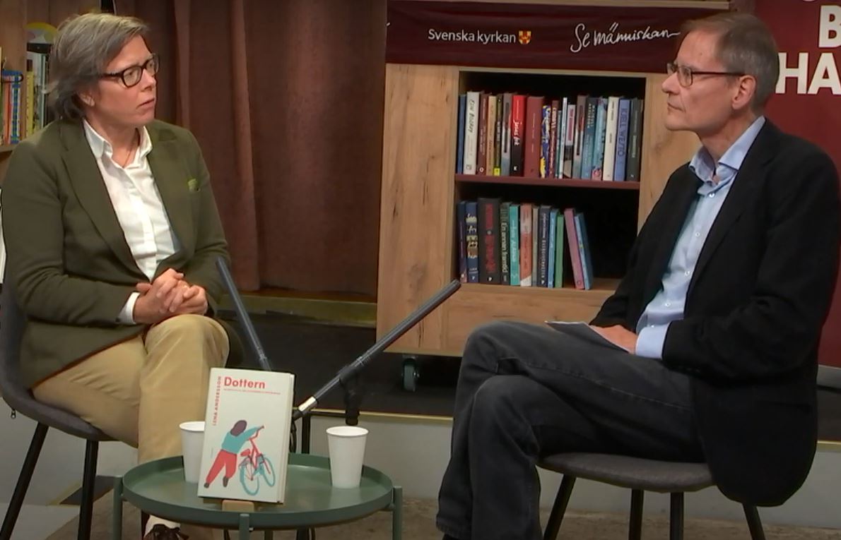 Man och kvinna sitter i en bokhandel och samtalar.