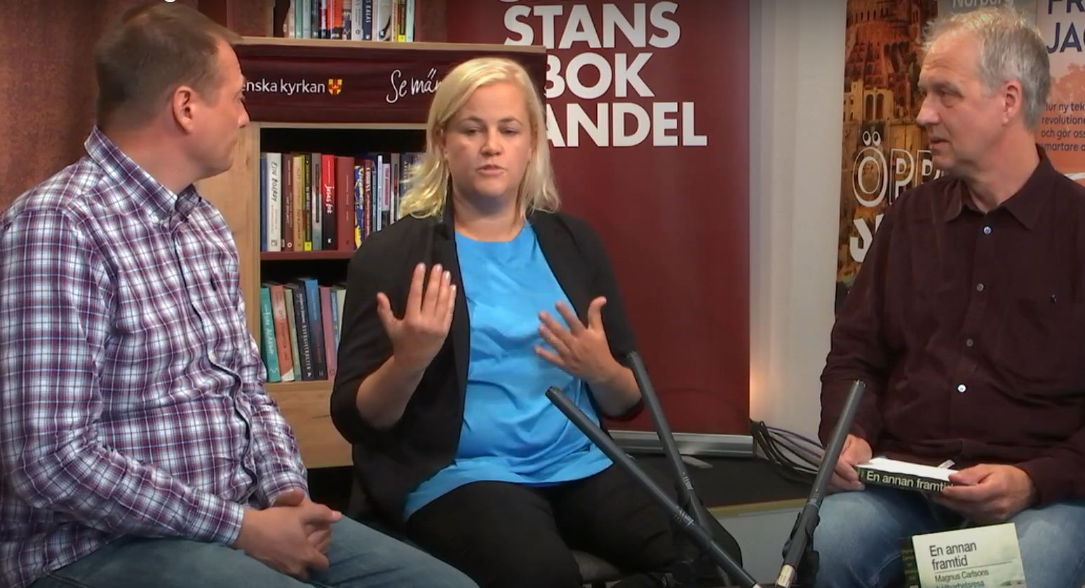 Två men och en kvinna samtalar i en bokhandel.