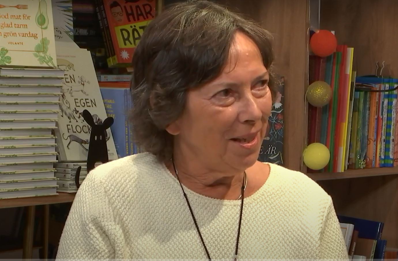 Kvinna småler och tittar snett åt höger.