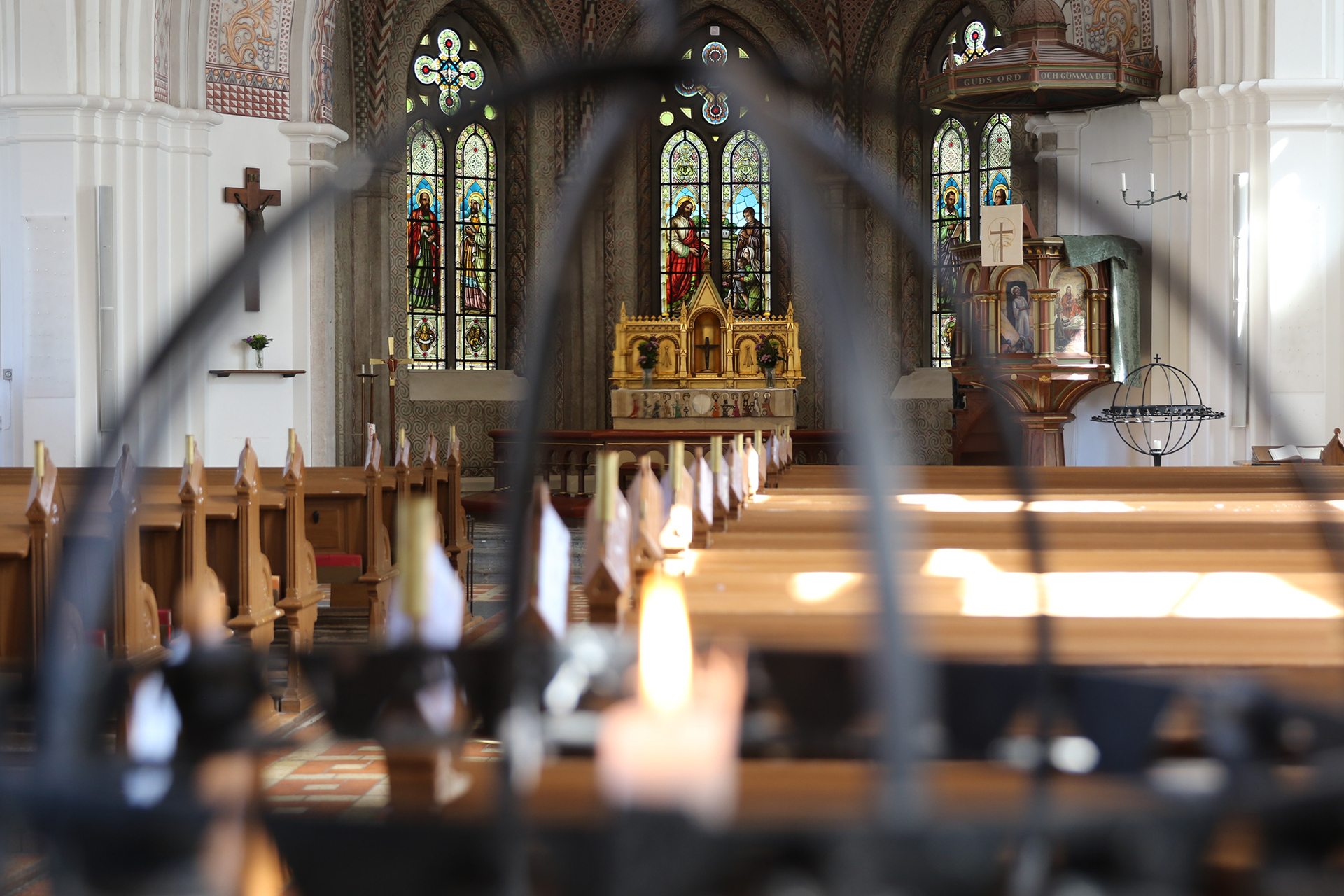 Interiör från Limhamns kyrka, koret ses genom ljusglob med tänt ljus