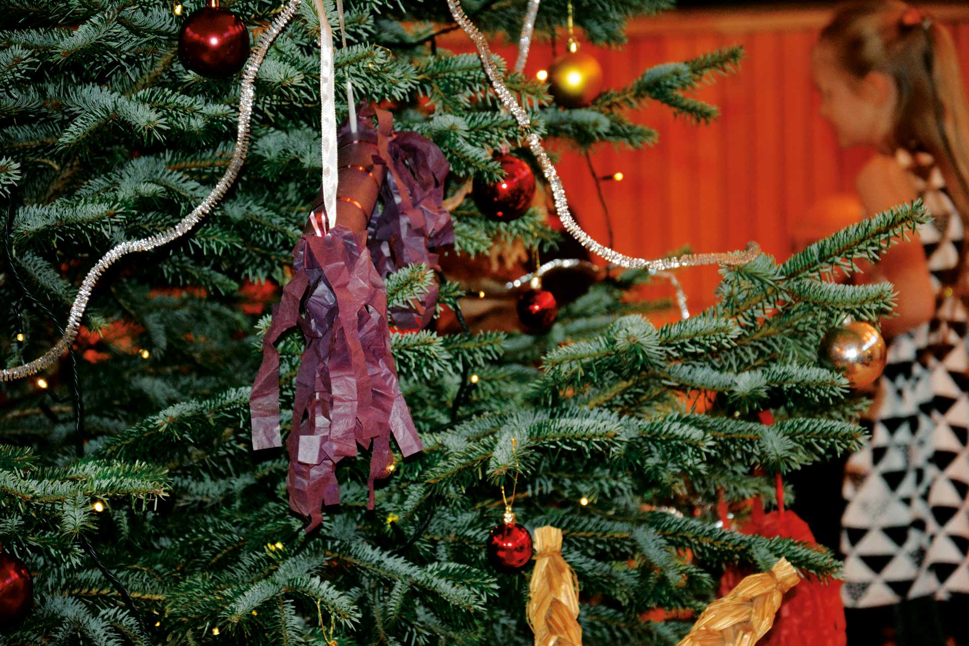 Julgran med smällkaramell och i bakgrunden barn.