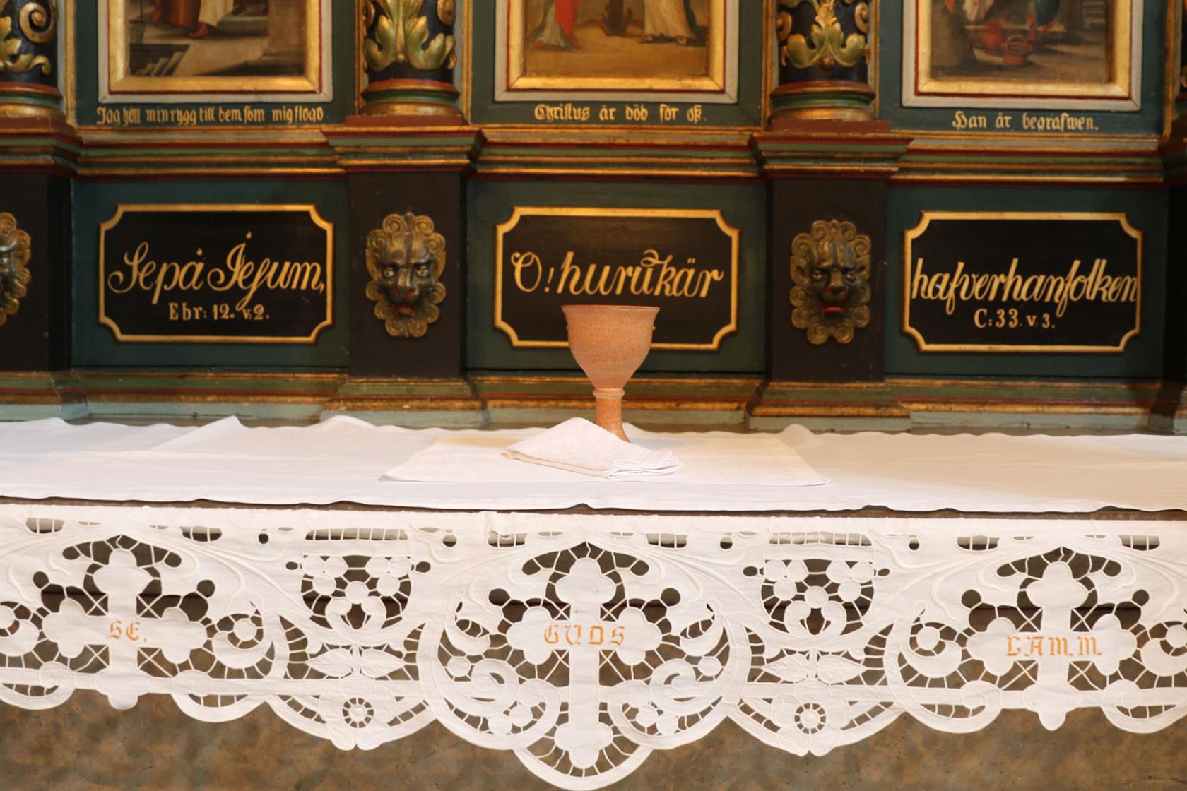 Nattvardskalk på altare framför altartavla