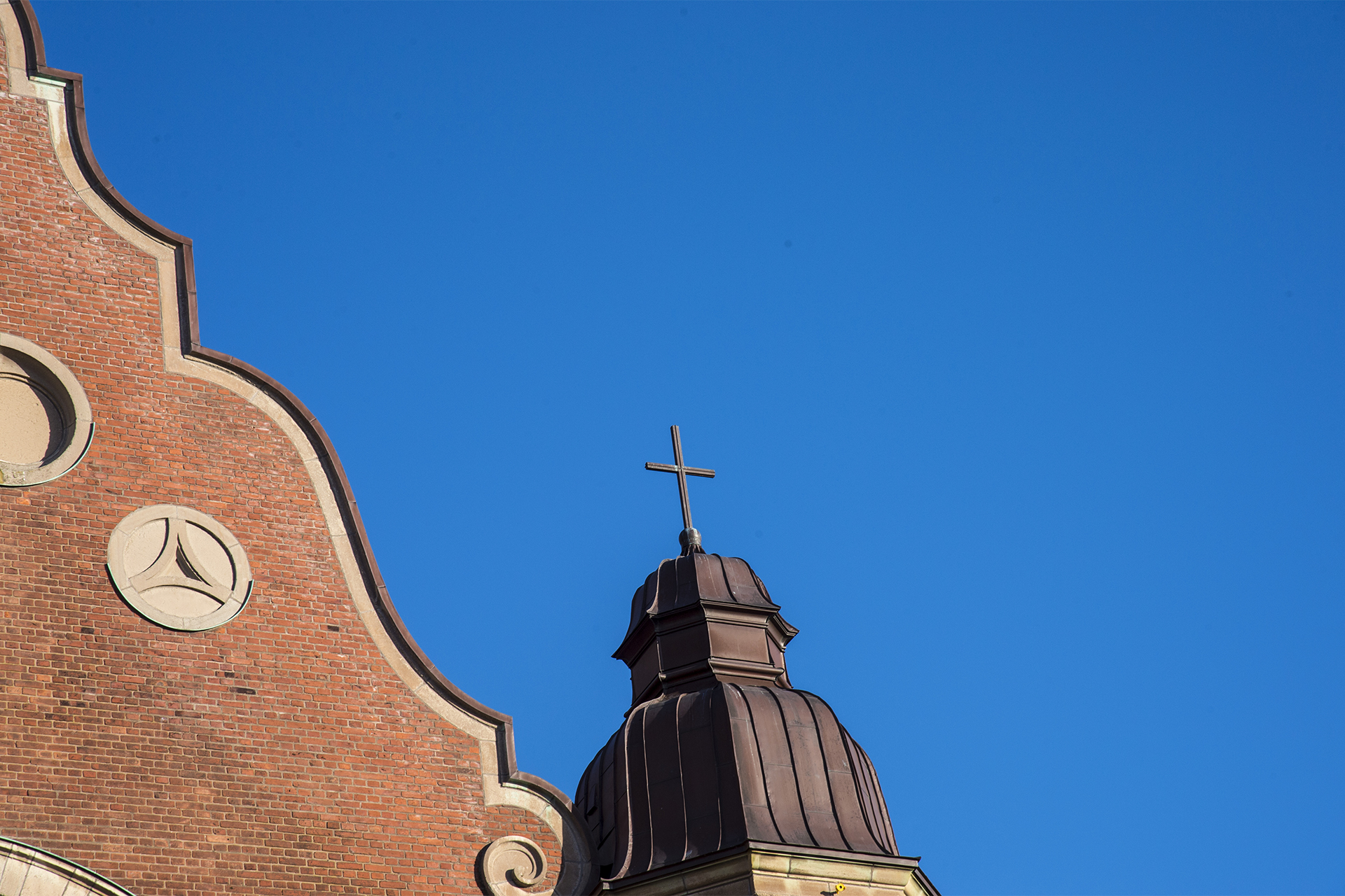 Kontur av kyrktak mot en blå himmel.