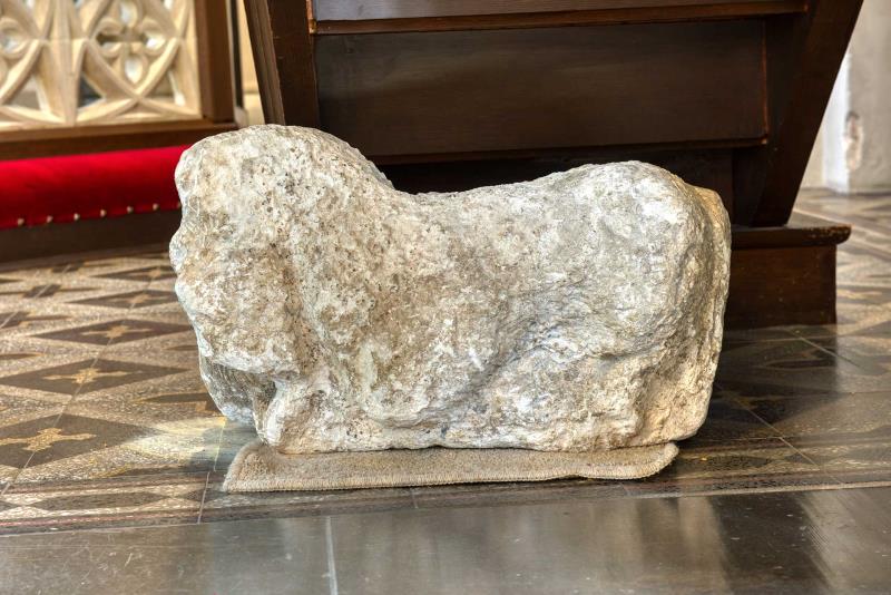 Illa åtgången stenskulptur föreställande ett liggande lejon.