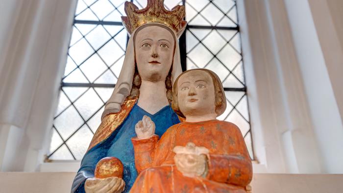 Staty i trä av jungfru Maria med Jesusbarnet i famnen och ett guldäpple i handen.