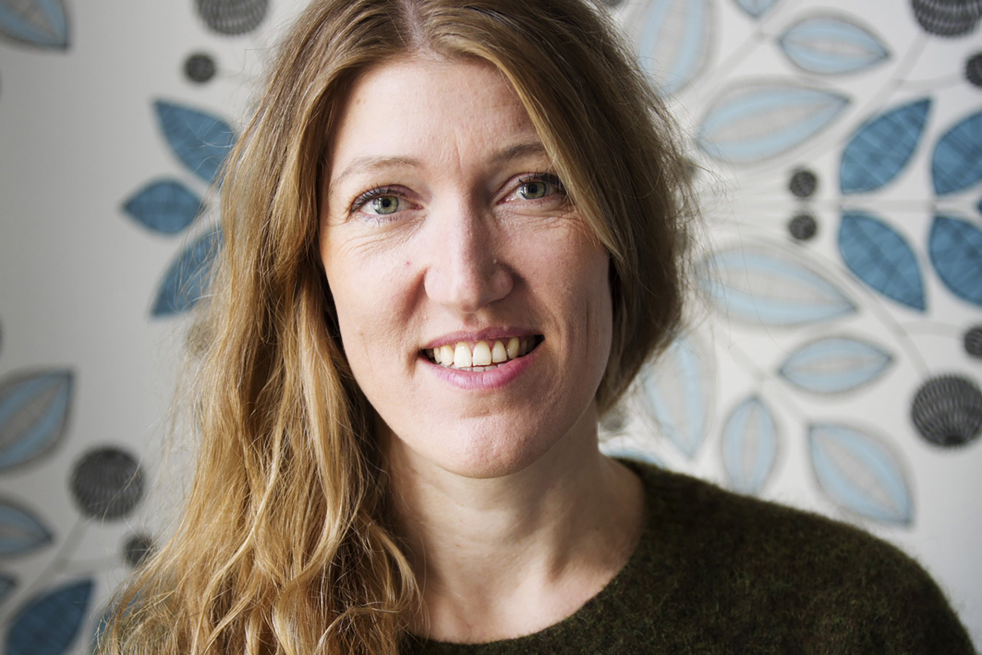 Kvinna med svart tröja, cendrefärgat långt hår.